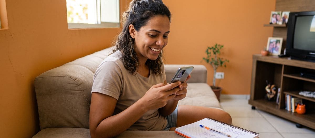 Mulher consulta pelo celular como aumentar o Score do Serasa rapidamente